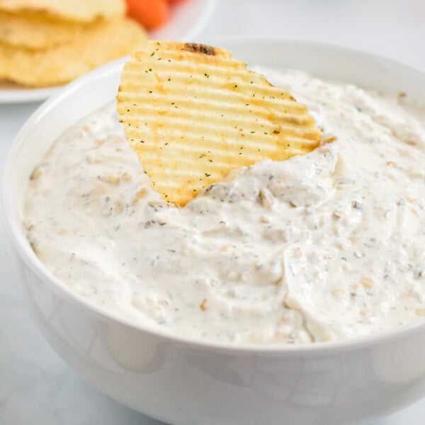 chip being dipped into sour cream chip dip