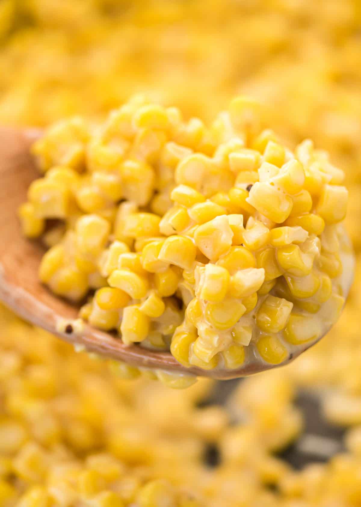 creamy corn on a wooden spoon