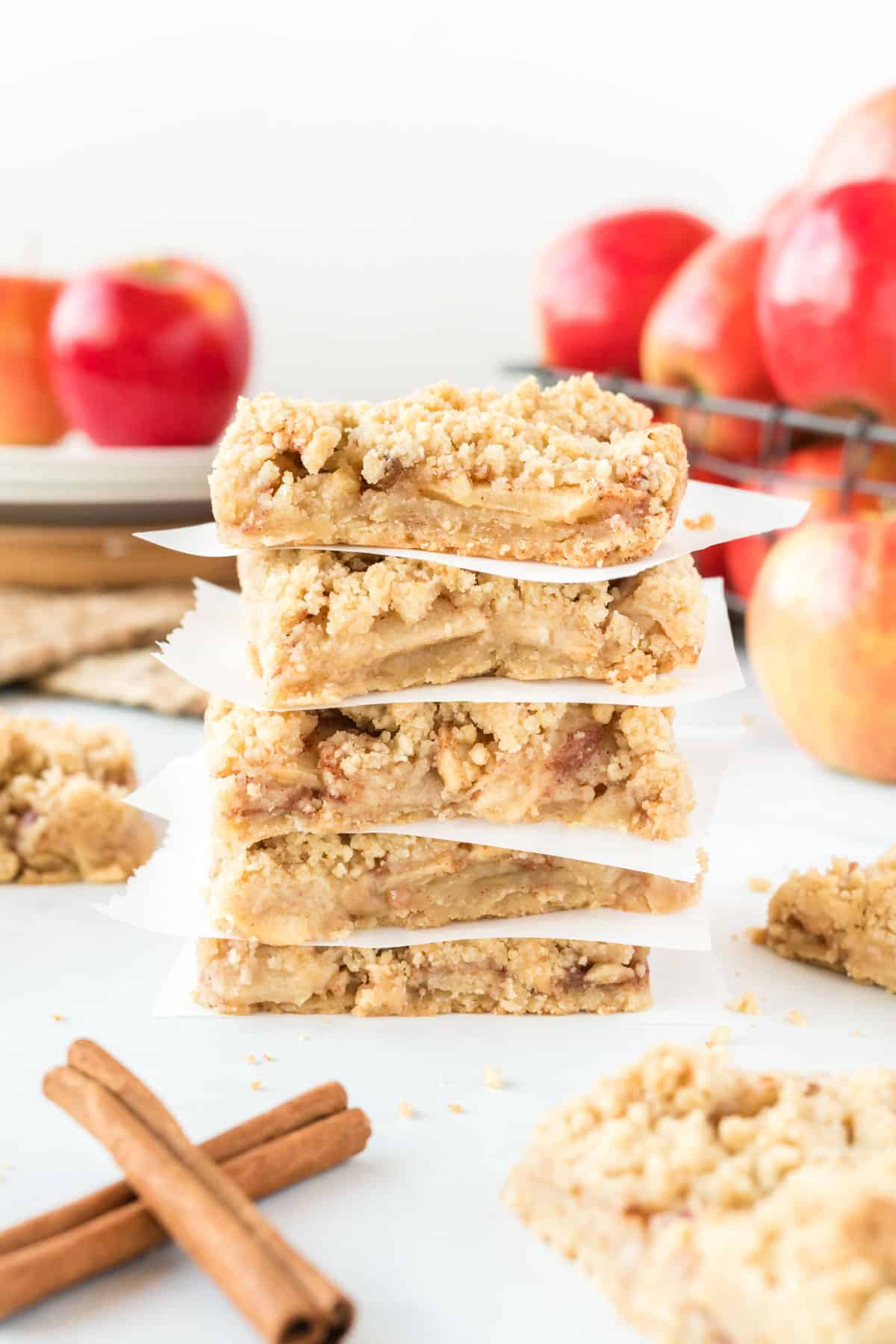 apple crisp bars stacked between squares of parchment paper
