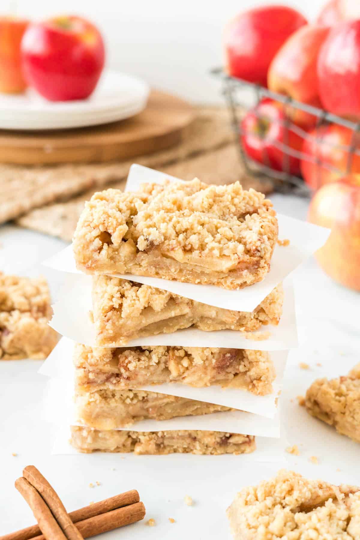 apple crisp bars stacked between squares of parchment paper