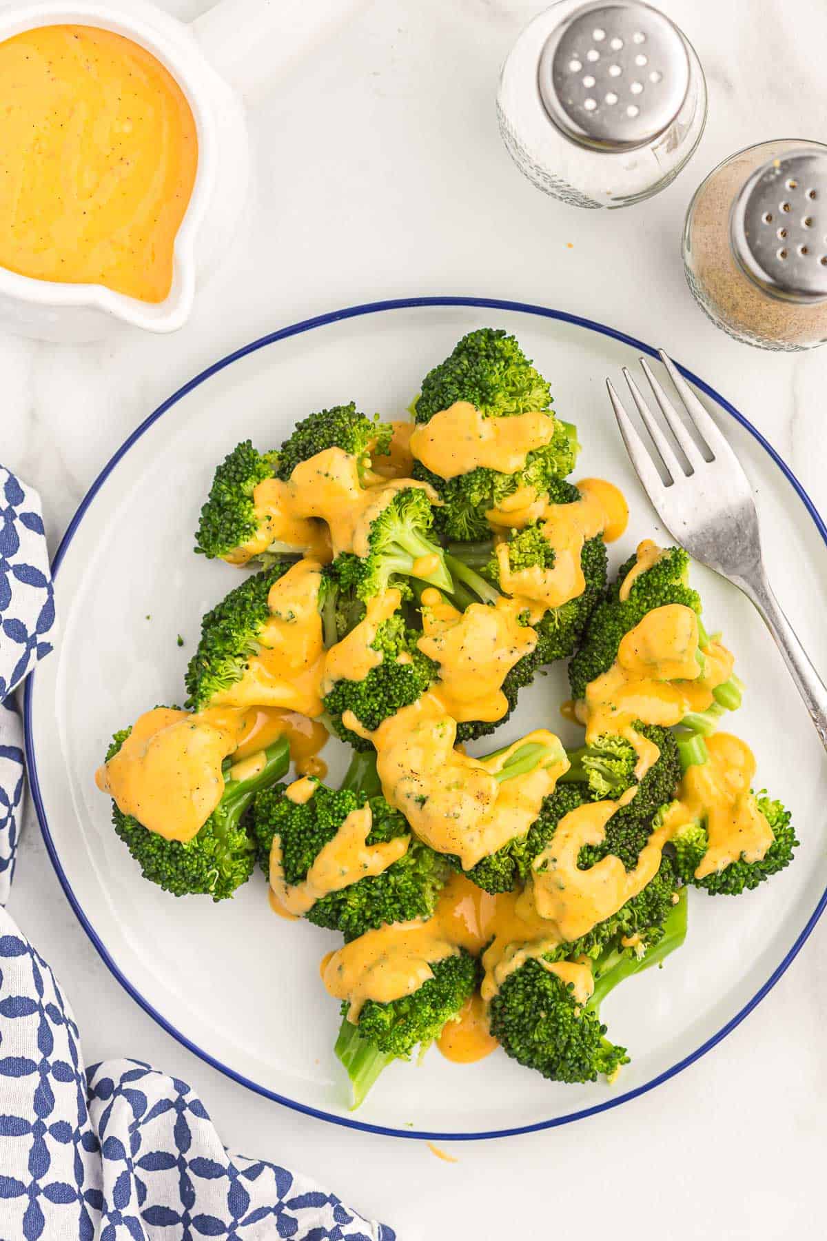 cheese sauce drizzled over steamed broccoli