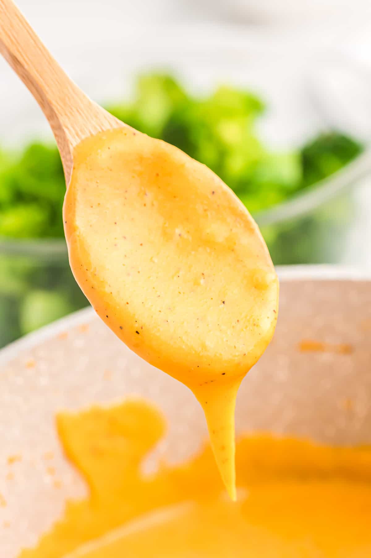 spoon dripping with cheese sauce