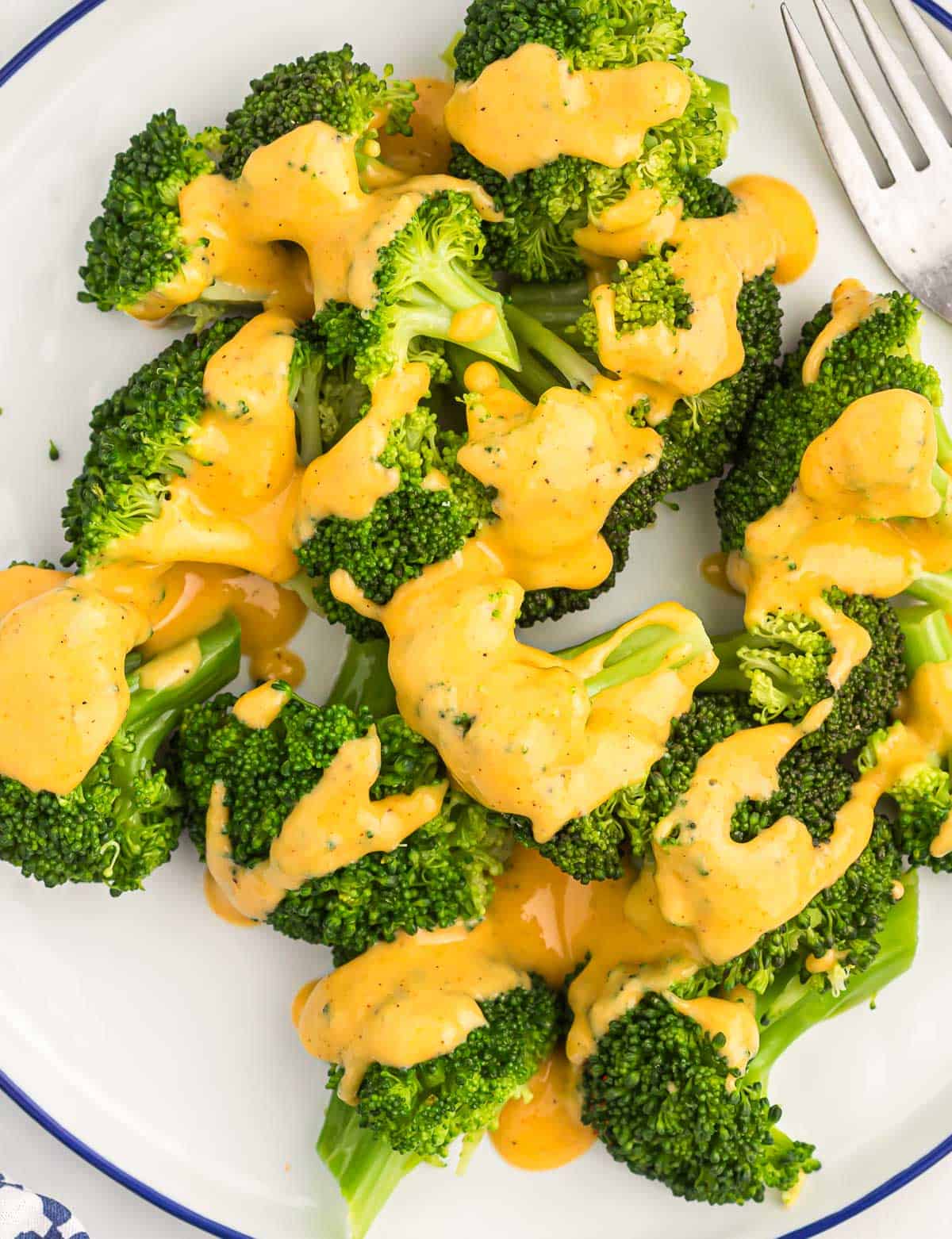 cheese sauce drizzled over steamed broccoli