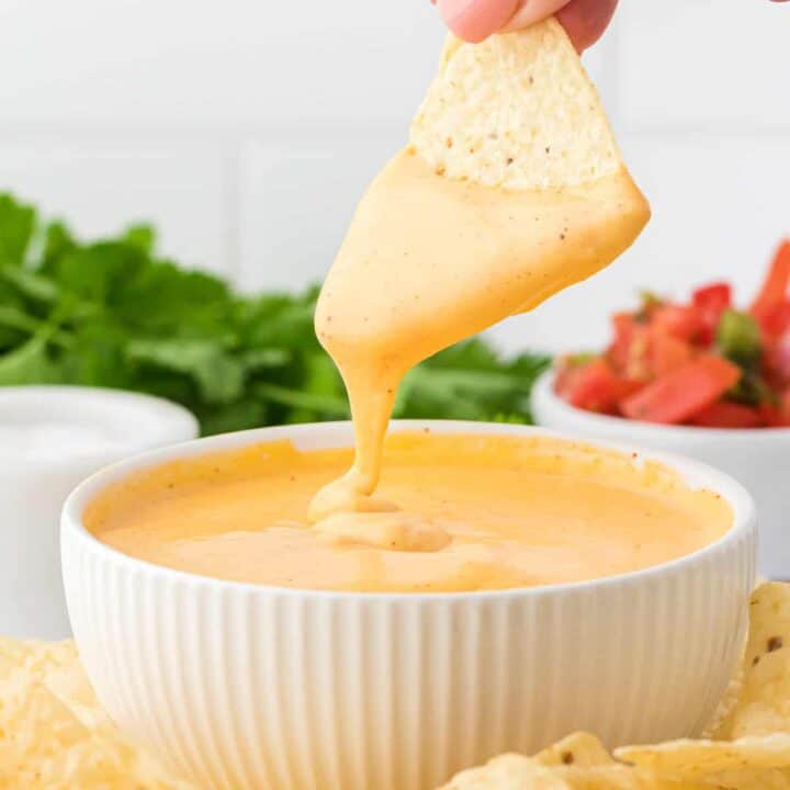 dipping a chip into nacho cheese sauce