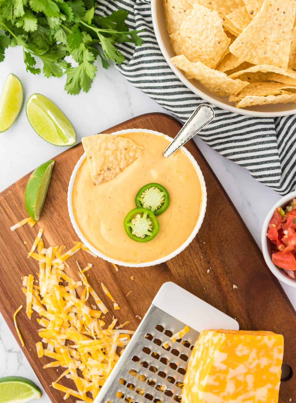 nacho cheese sauce in a bowl topped with jalapeno slices