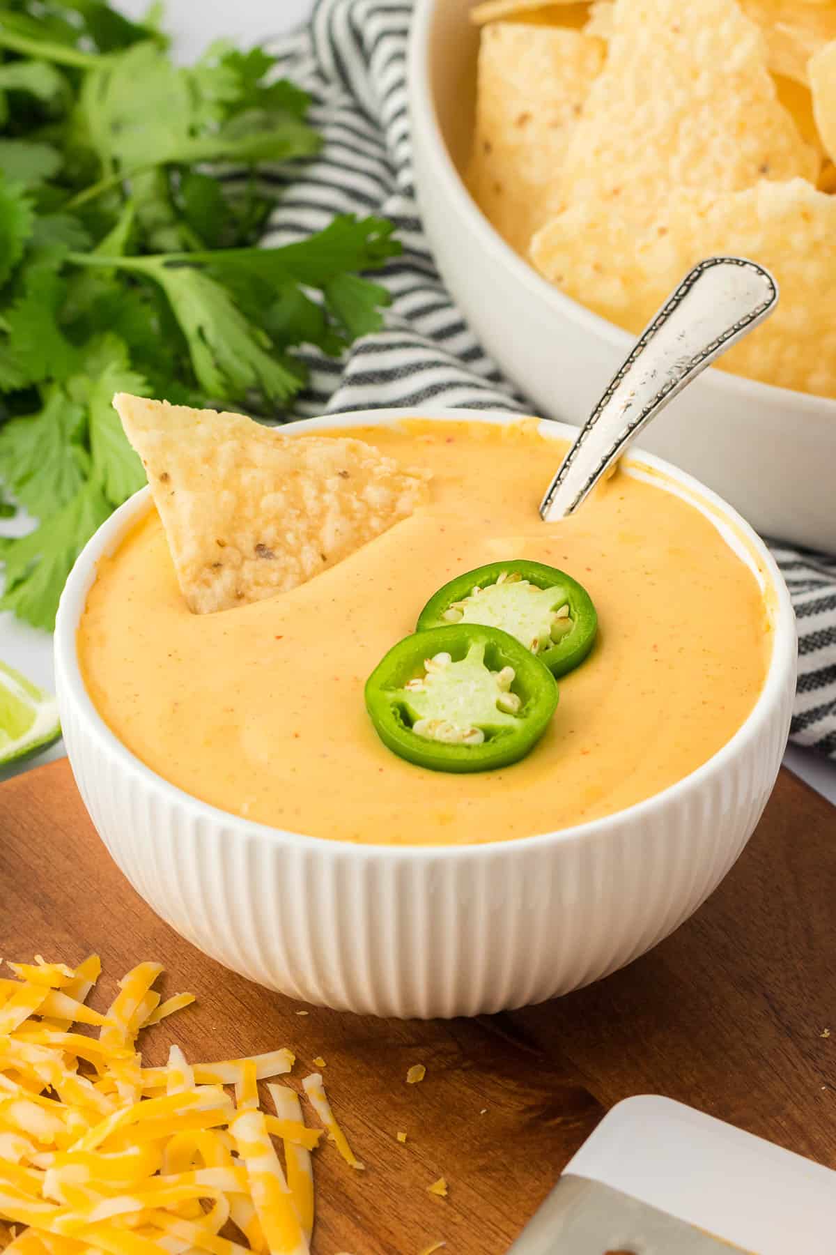 nacho cheese sauce in a bowl topped with jalapeno slices