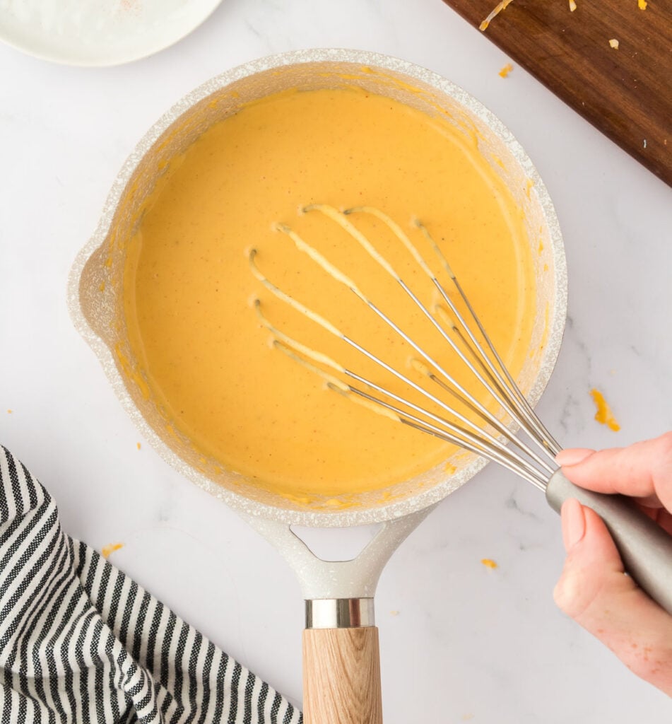 whisking cheese sauce