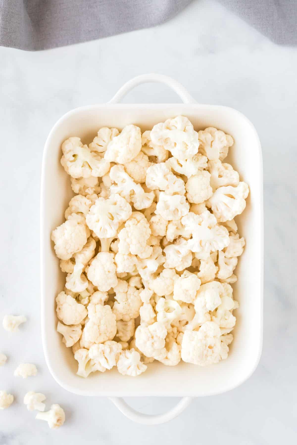 cauliflower florets in a white baking dish