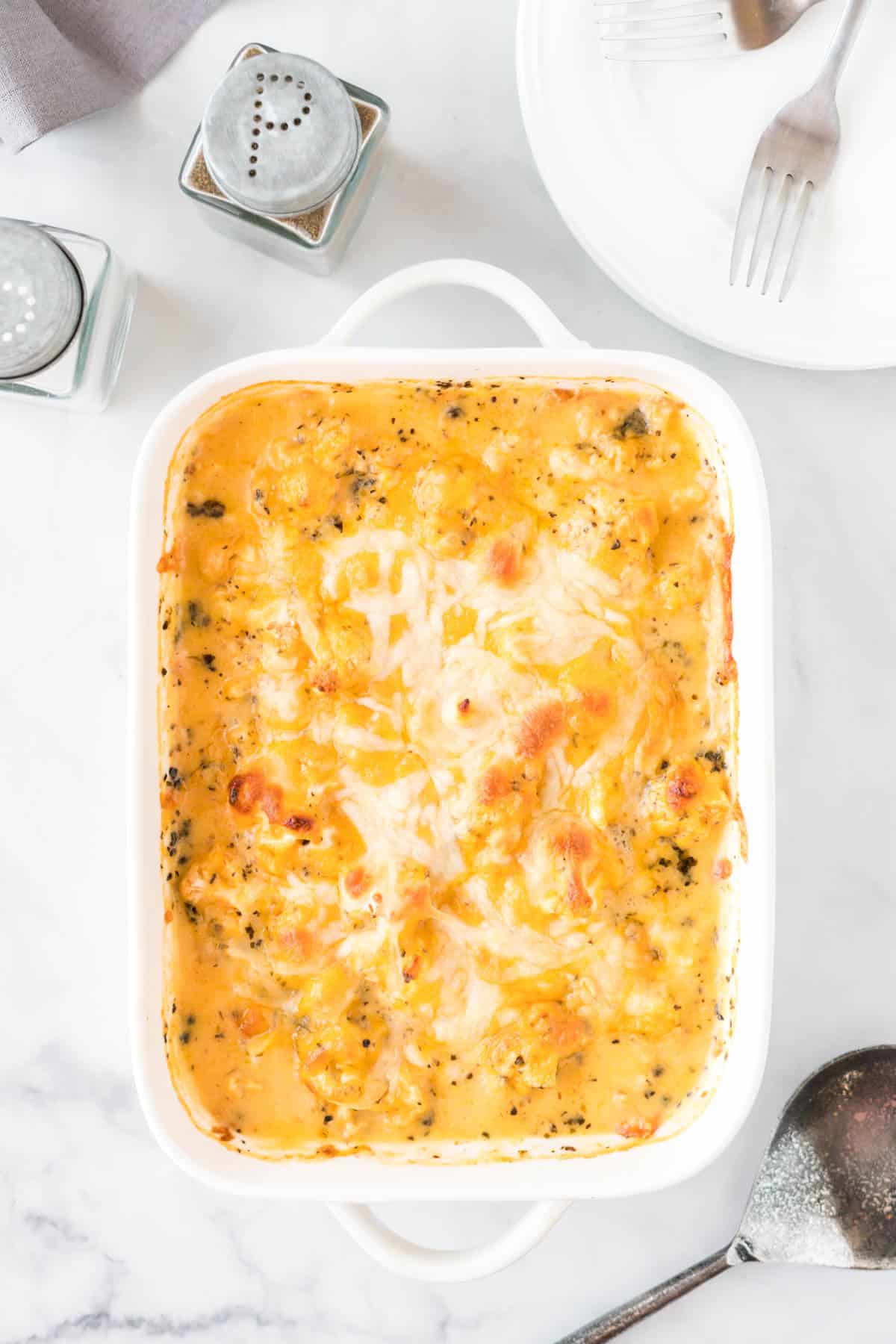 cheesy cauliflower casserole in a white baking dish