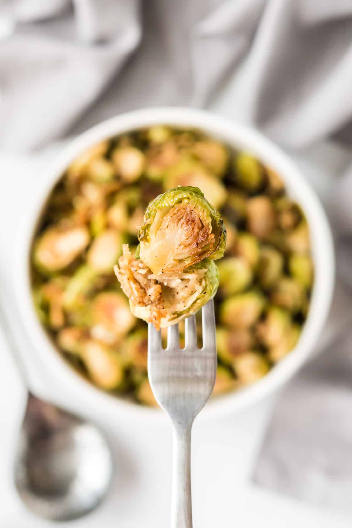 a fork with a roasted brussel sprout on it