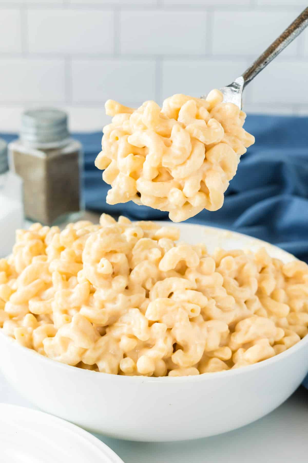 a spoon taking a scoop of mac and cheese from a bowl