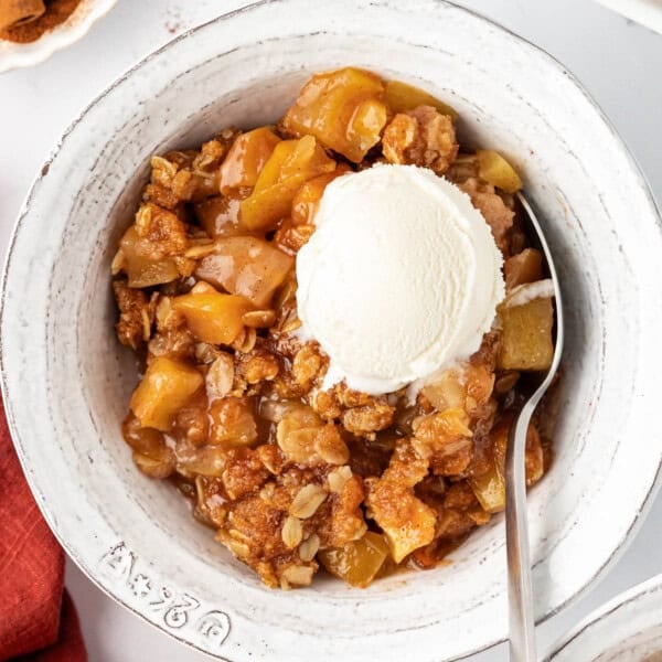 vegan apple crisp topped with a scoop of ice cream