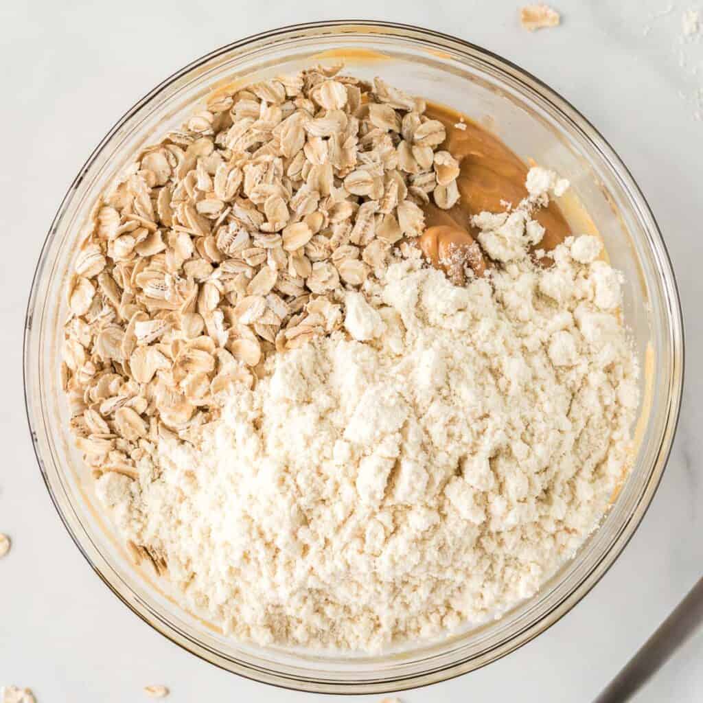 adding protein powder and oats to the peanut butter