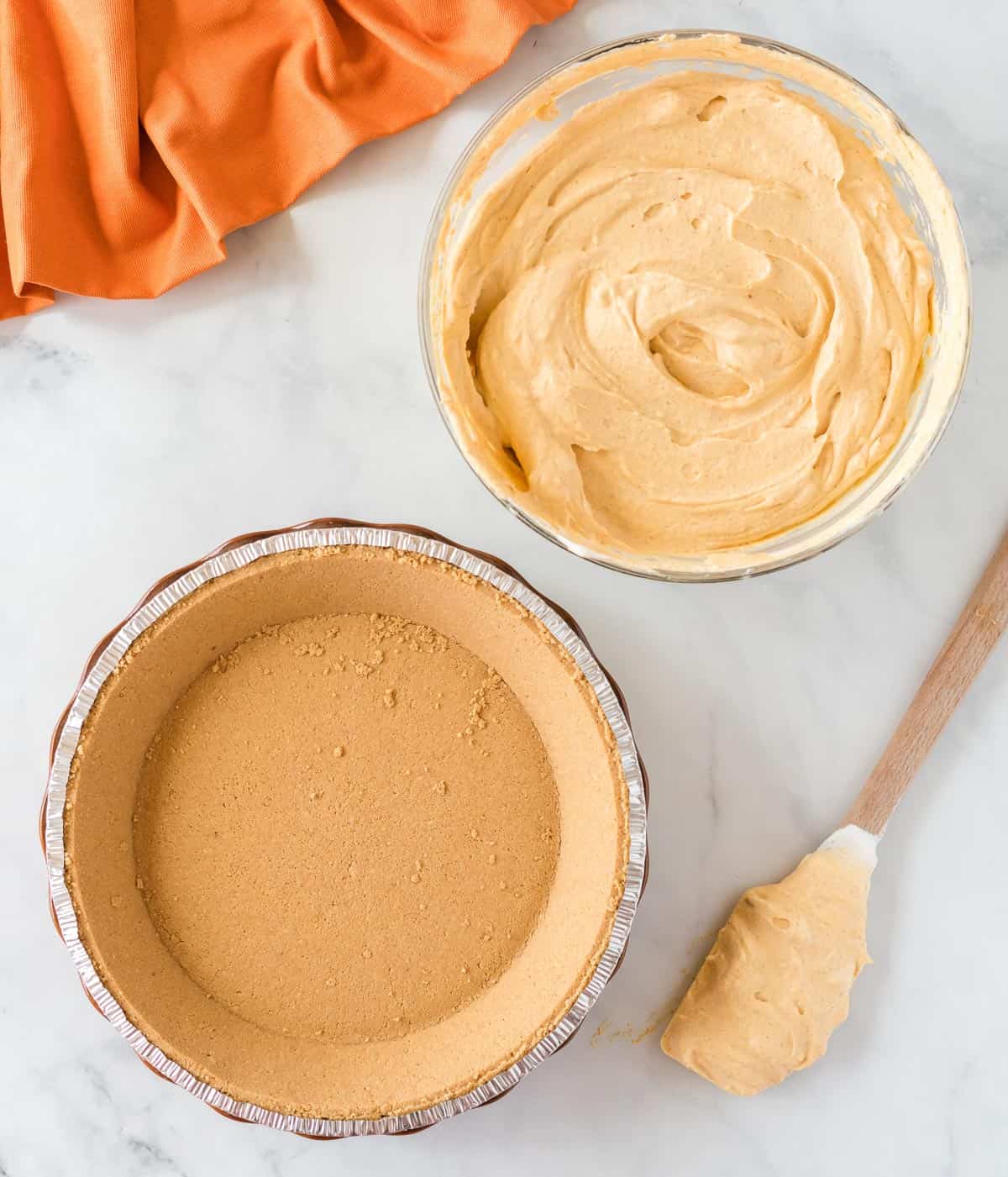 pumpkin cream pie filling next to a graham cracker crust