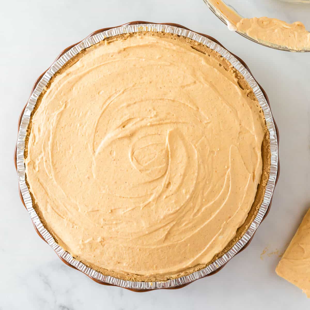 pumpkin pie filling smoothed out in the graham crust