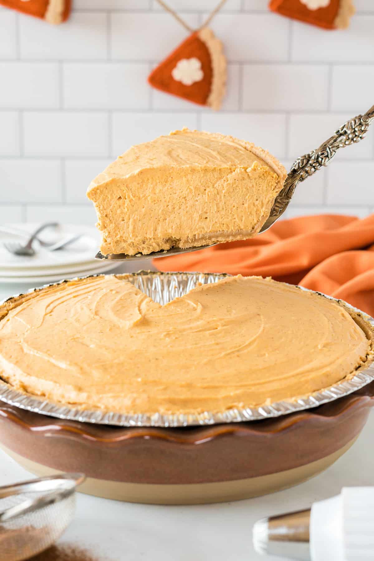taking a piece of pumpkin pie from the pie dish