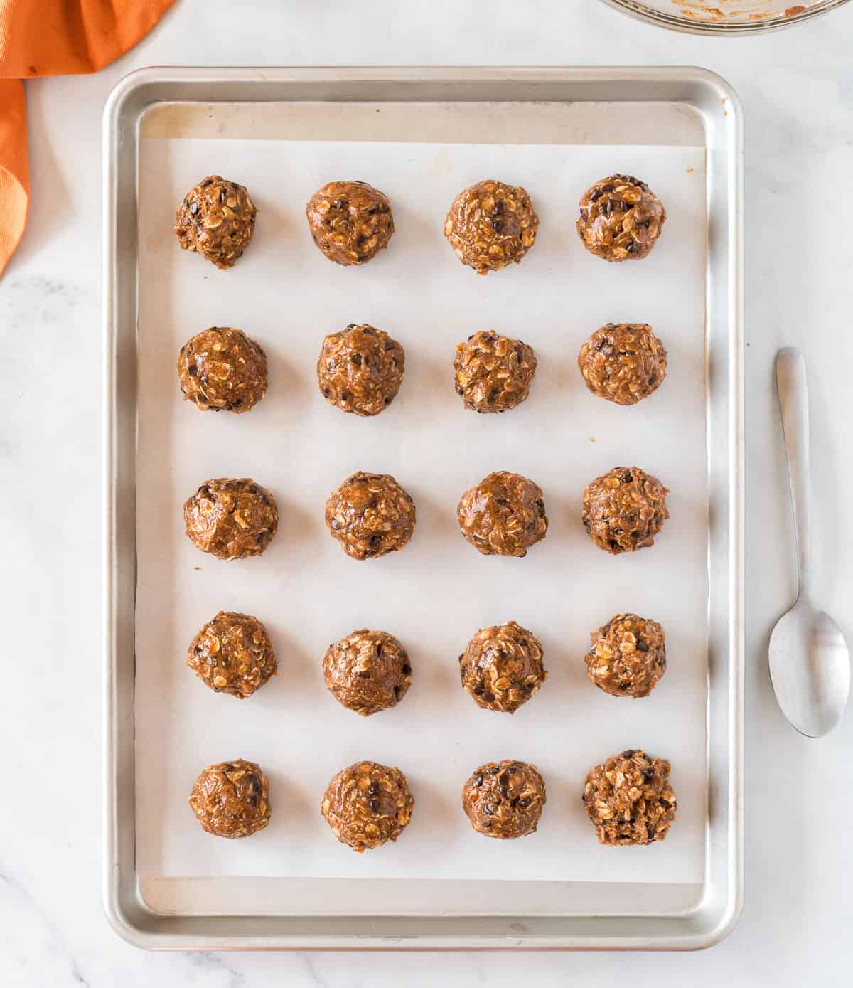 pumpkin protein balls lined up on a baking sheet