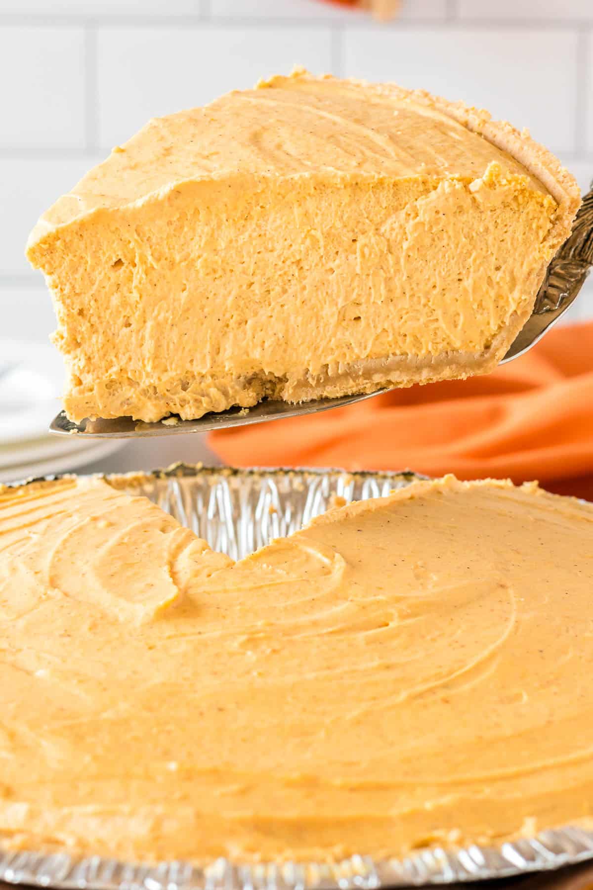 taking a slice of whipped pumpkin pie from the pie dish