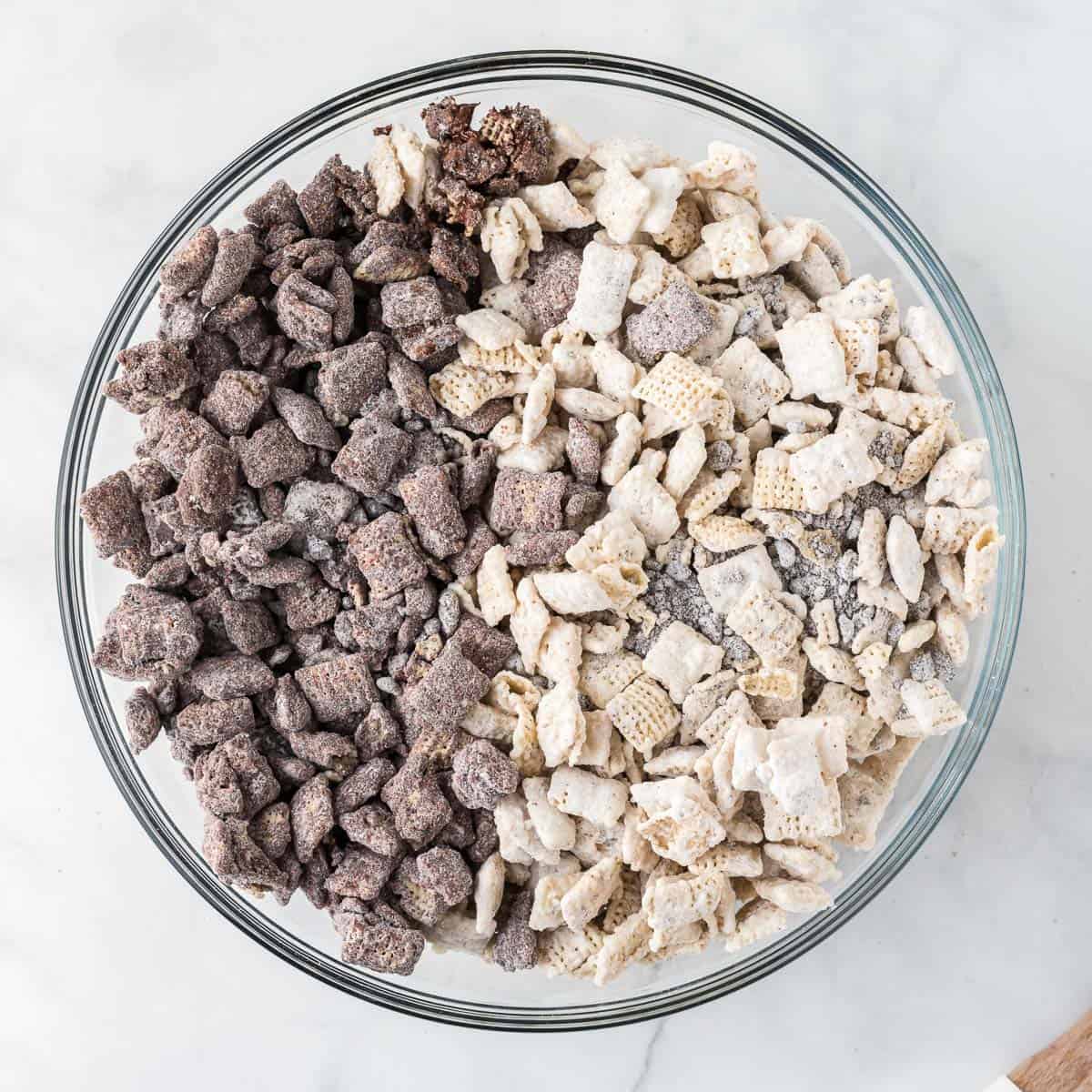 chocolate and white chocolate muddy buddies added to a large bowl