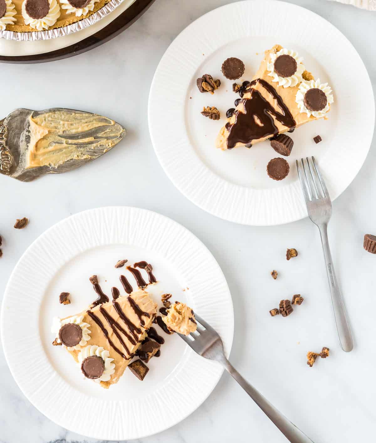 two plates with a slice of peanut butter pie on each one