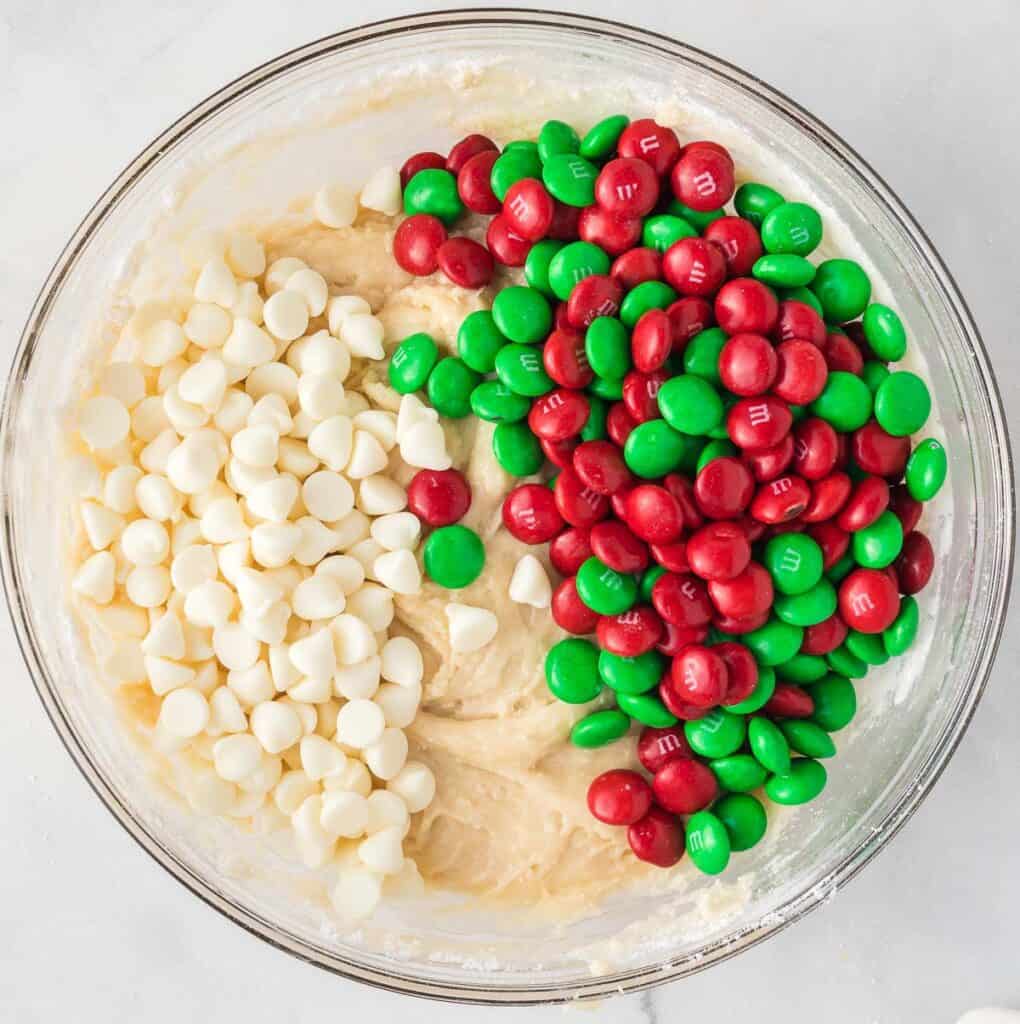 adding m&m's and white chocolate chips to the batter