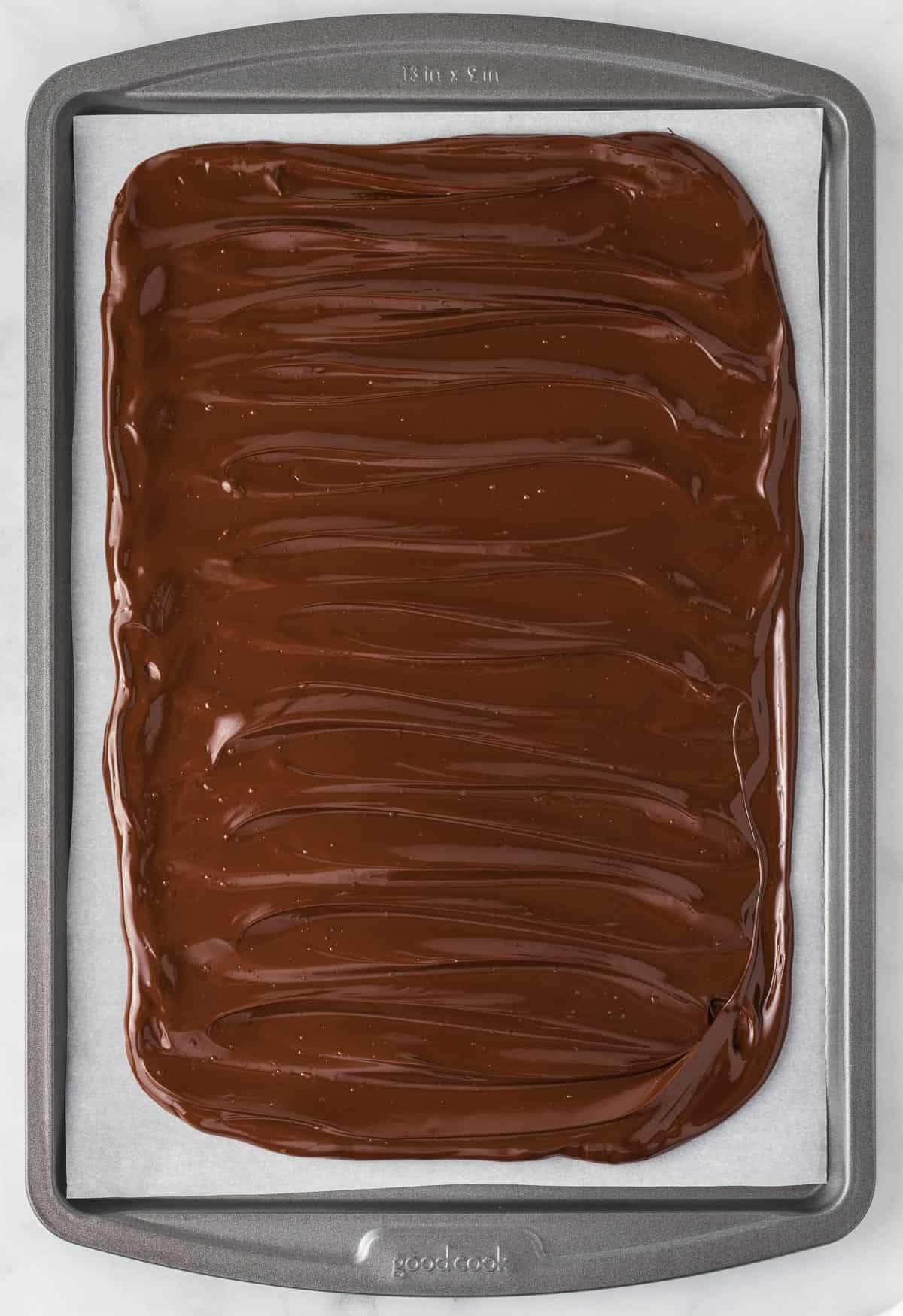 dark chocolate spread on a parchment paper lined baking sheet