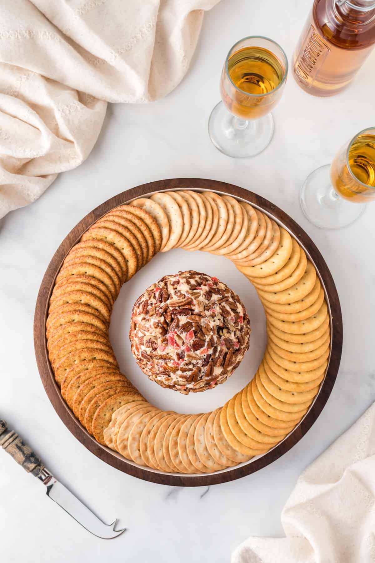 pimento cheese ball on a platter surrounded by crackers