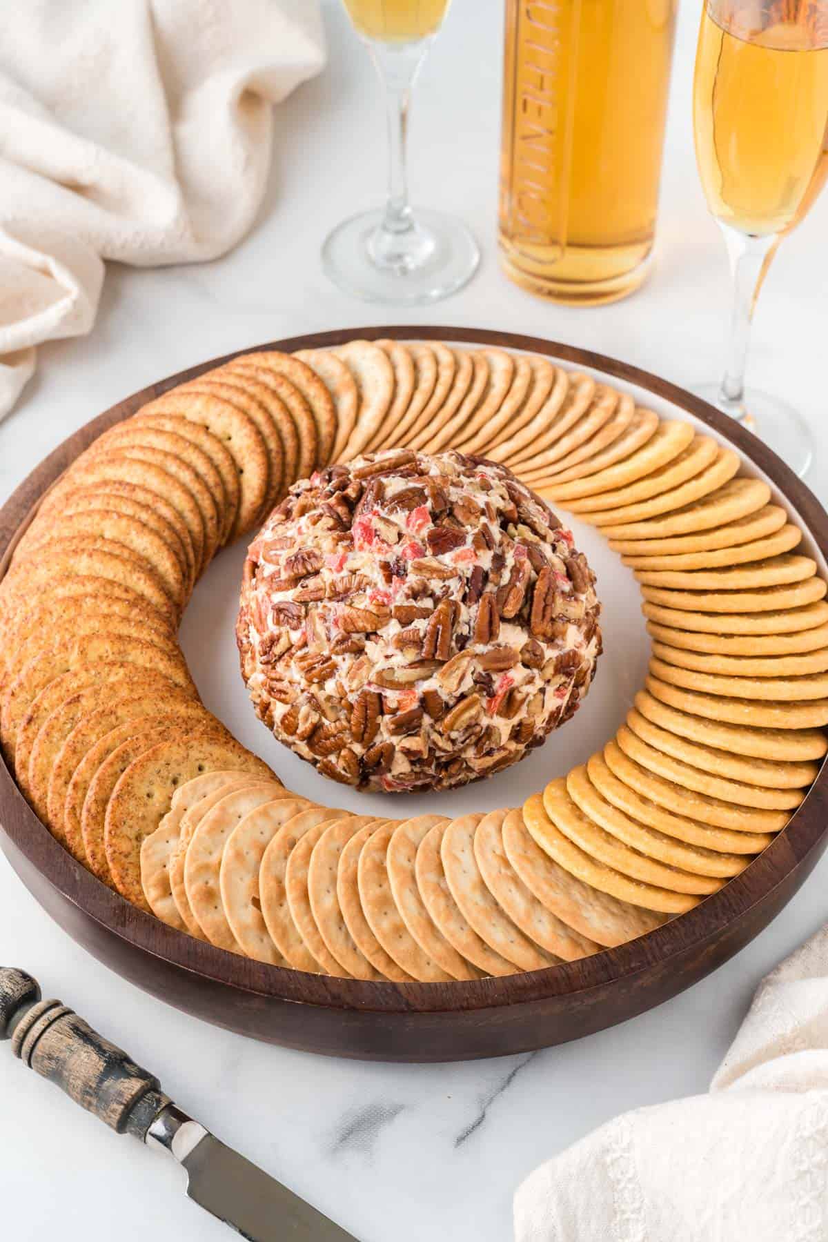 pimento cheese ball on a platter surrounded by crackers