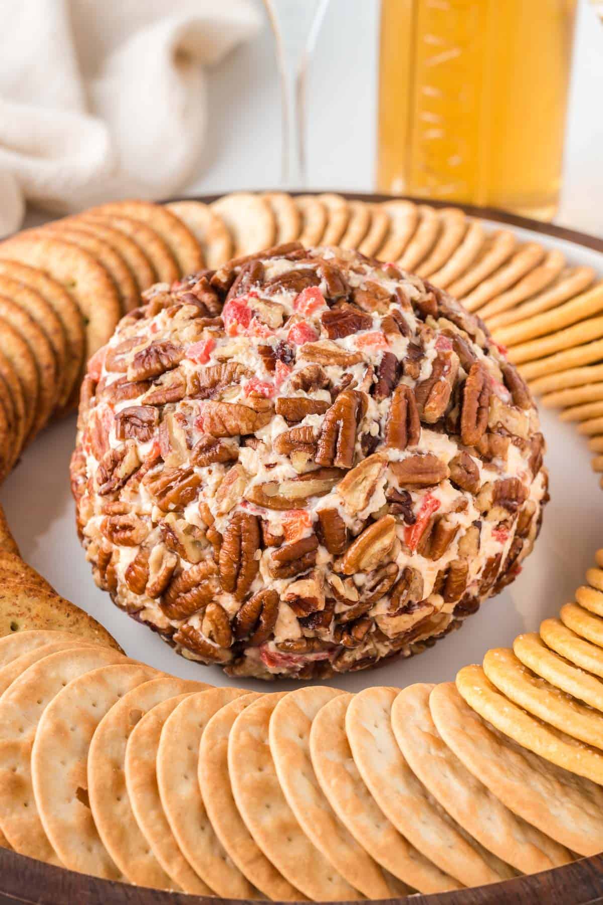 pimento cheese ball on a platter surrounded by crackers