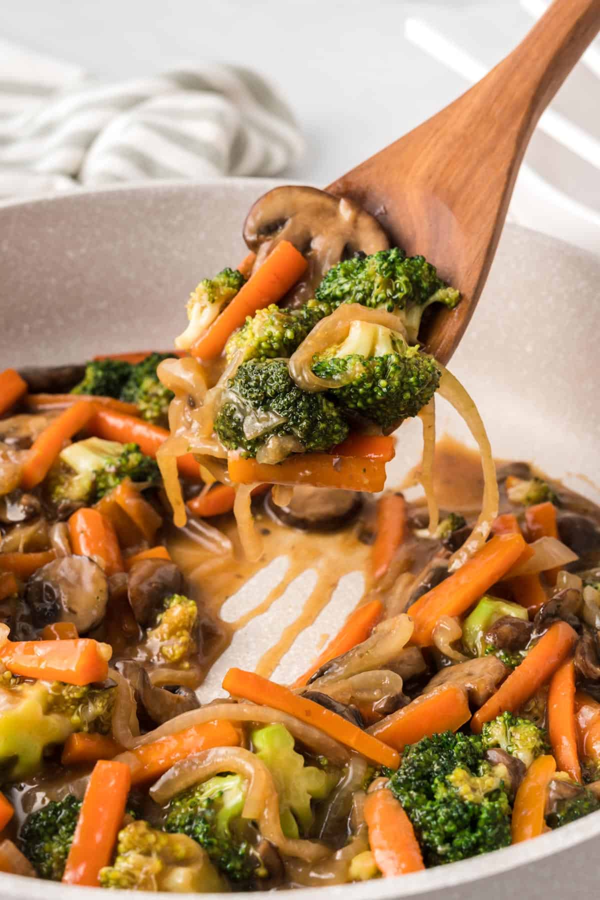 wooden spoon taking a serving of teriyaki vegetables