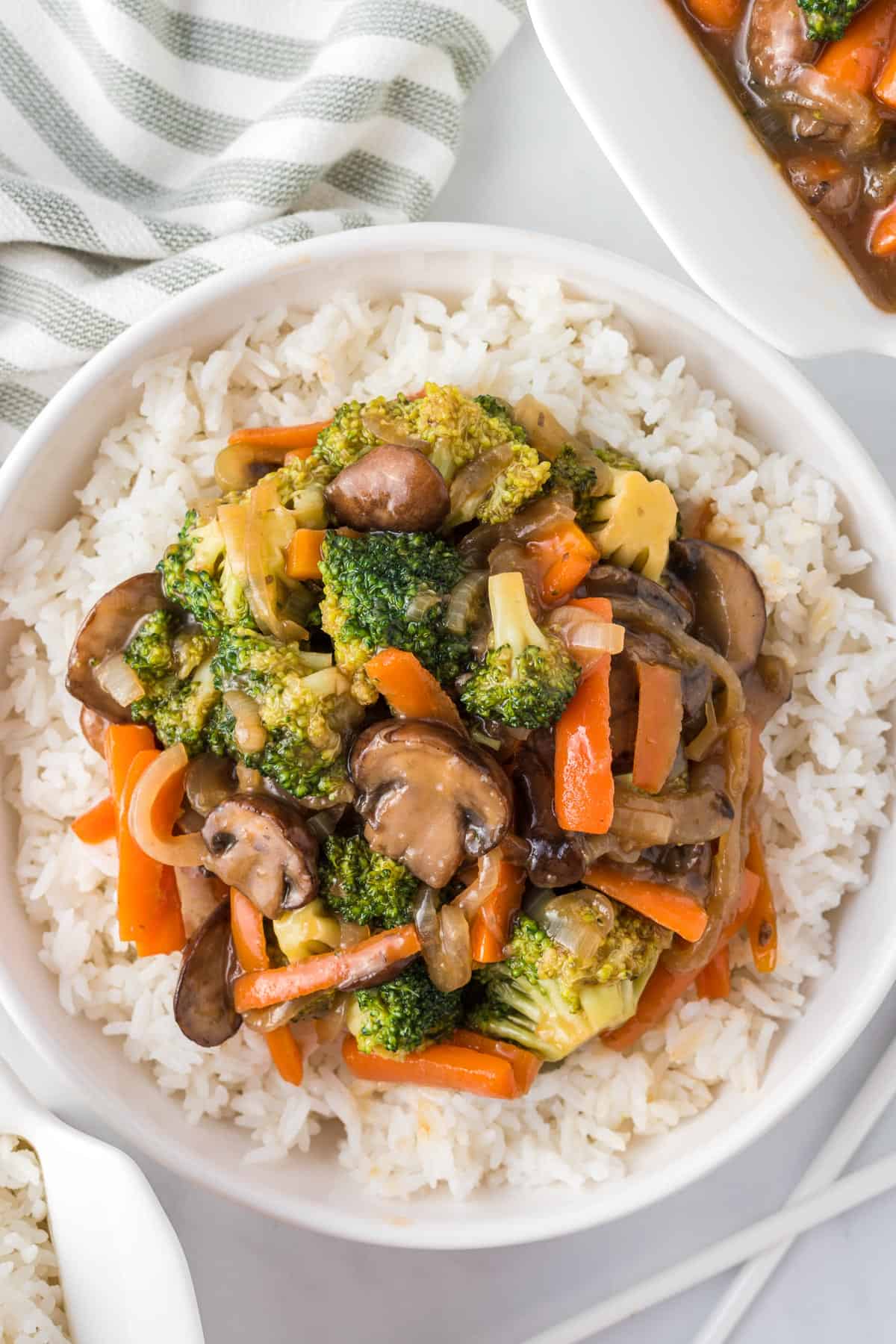 teriyaki vegetables over white rice in a bowl