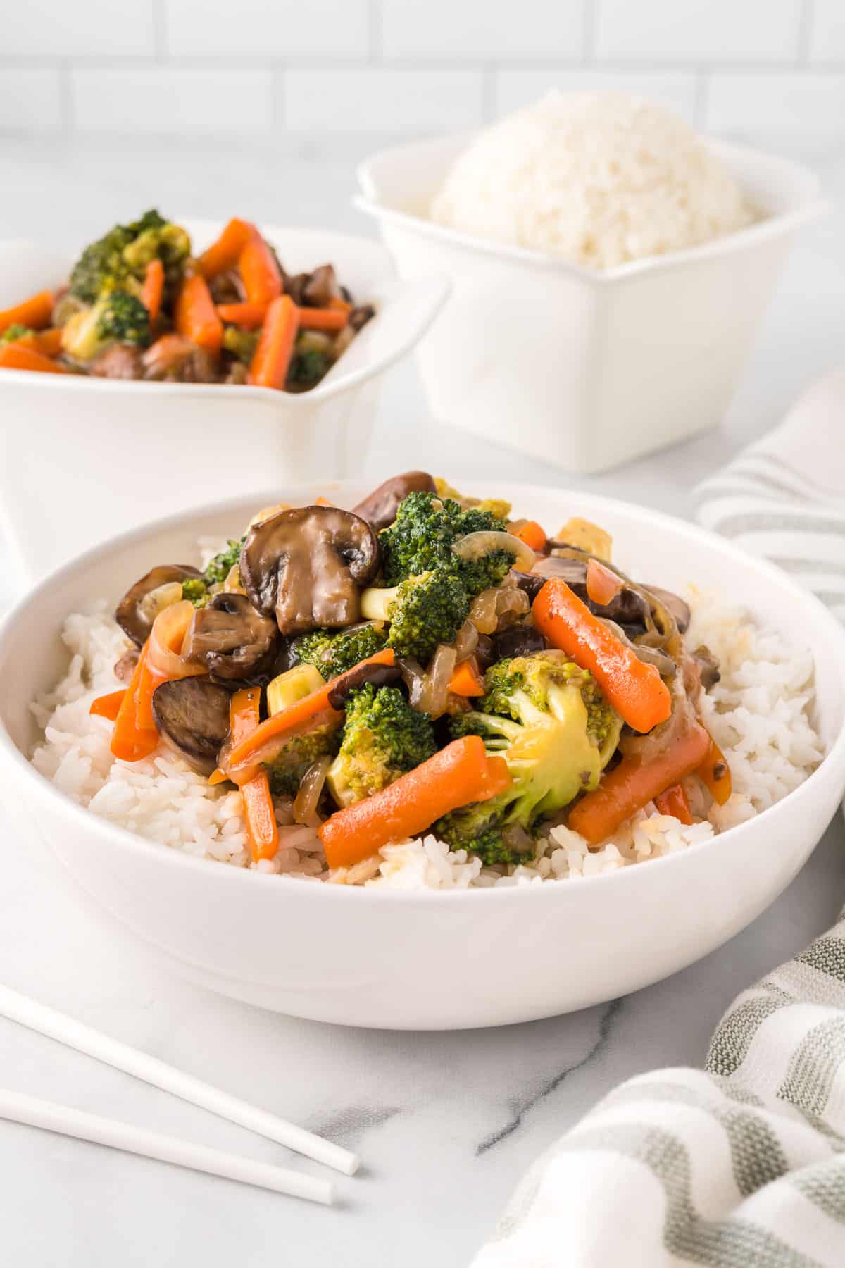 teriyaki vegetables over white rice in a bowl