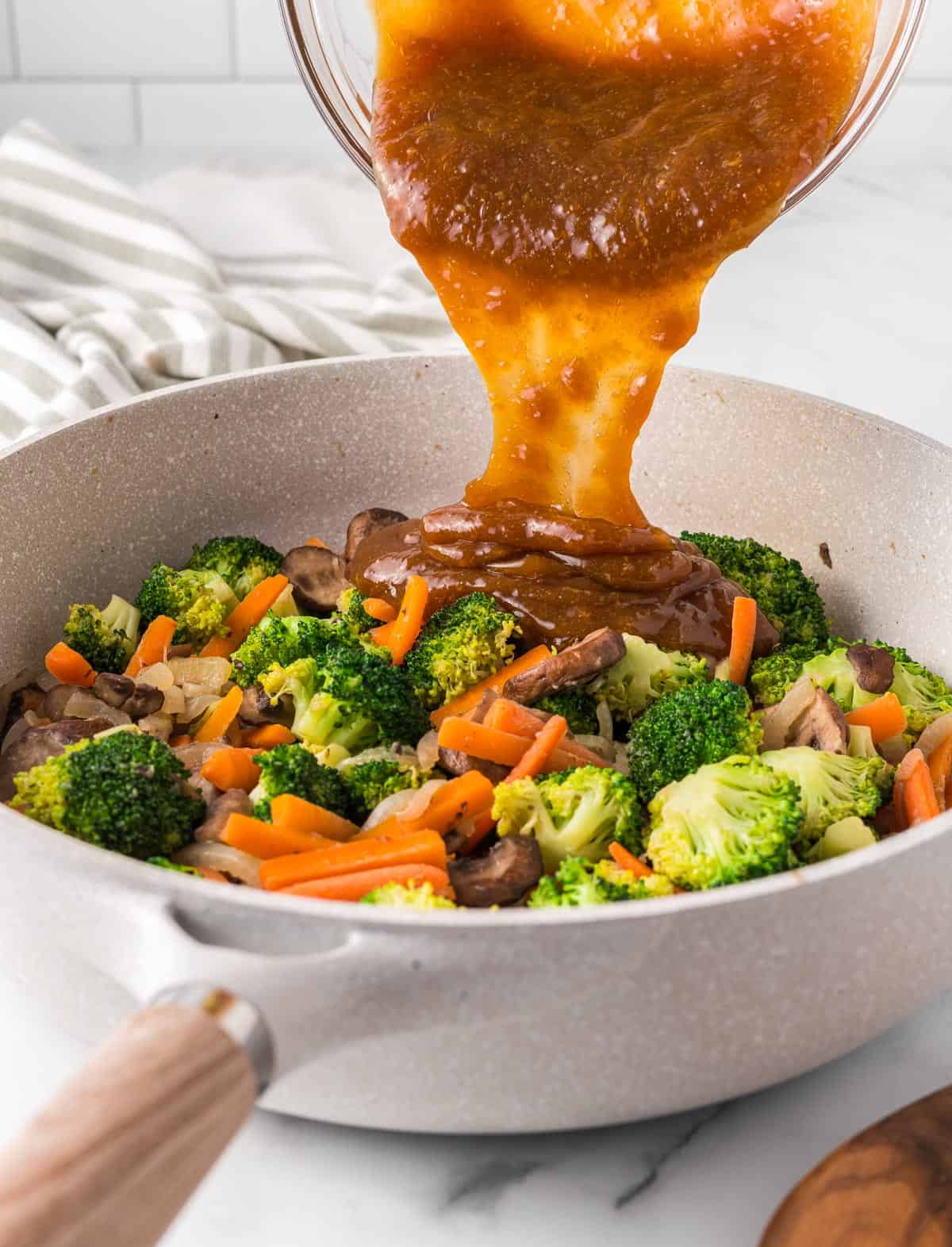 pouring the teriyaki sauce over the vegetables