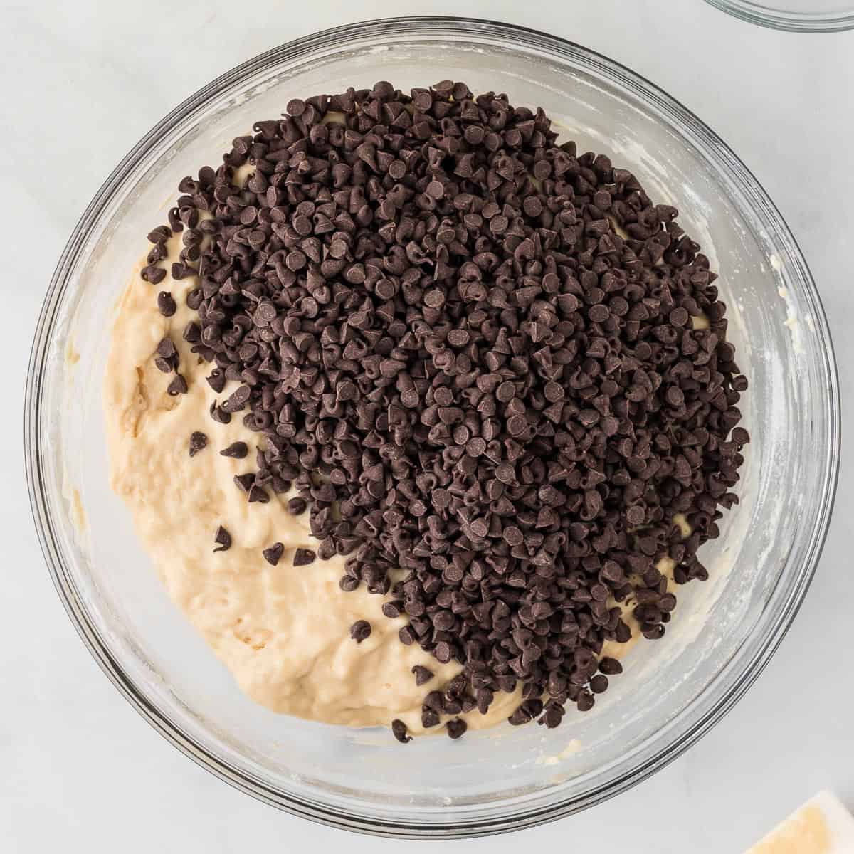 adding the mini chocolate chips to the muffin batter