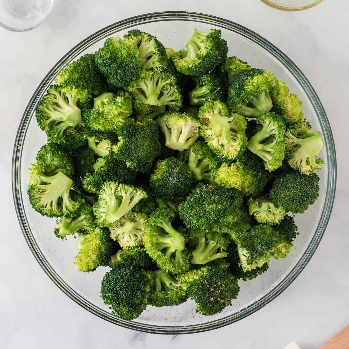 broccoli florets mixed with oil and spices in a bowl