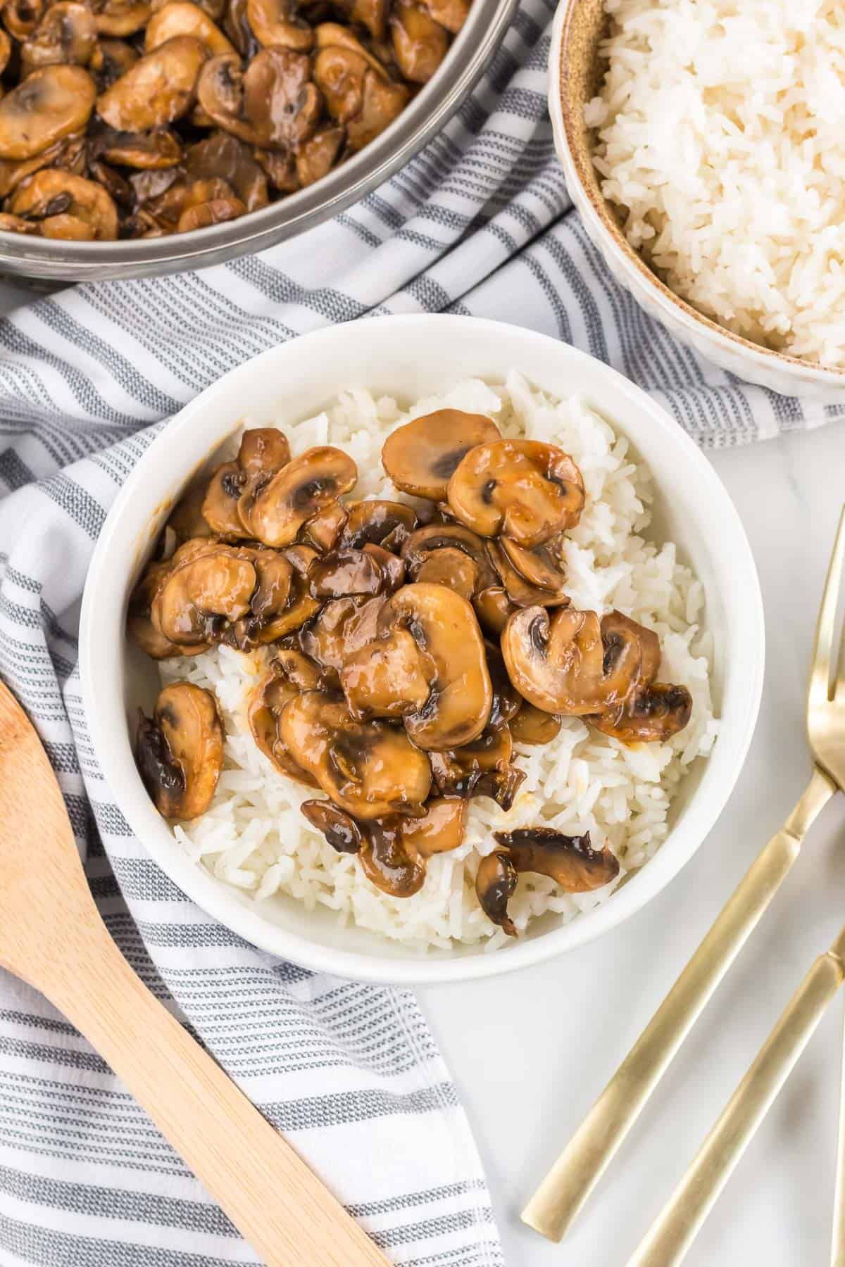 teriyaki mushrooms over rice in a white bowl