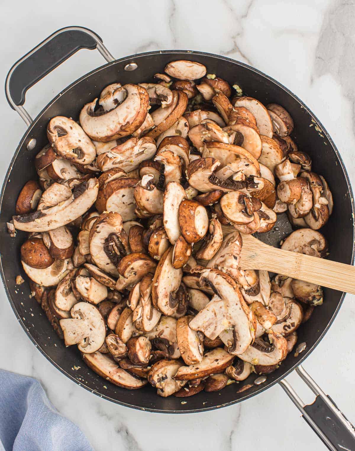 adding mushrooms to a skillet