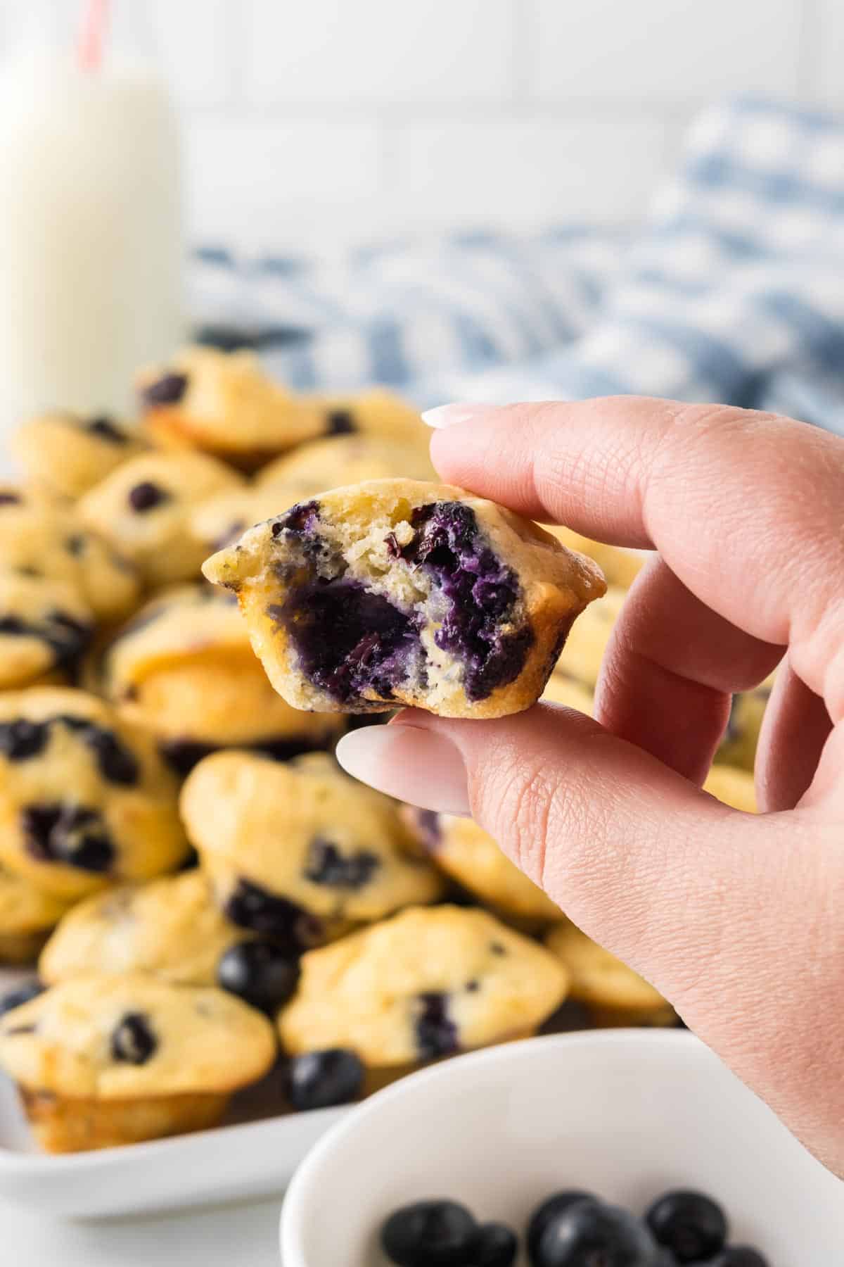 hand holding a mini muffin with a bite taken out