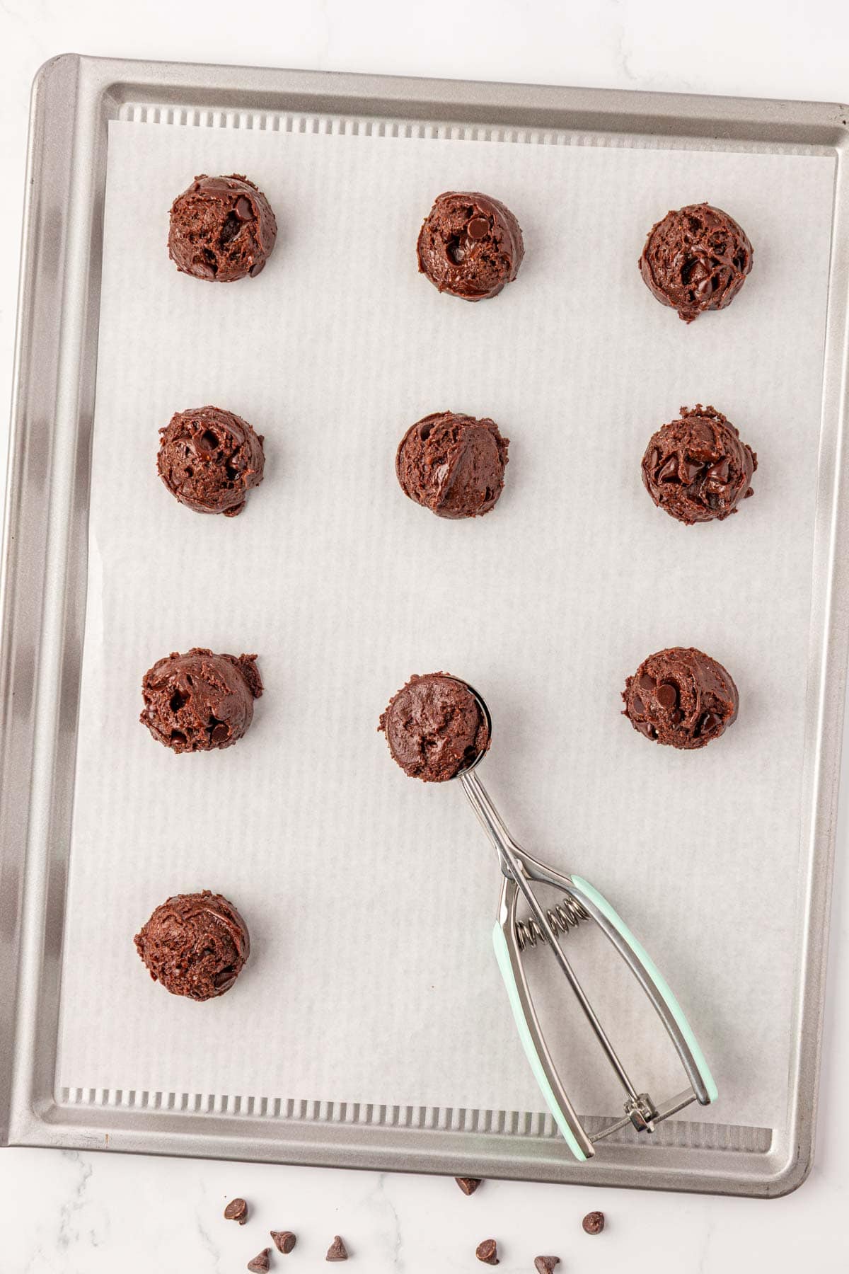 using a mini cookie scoop to place batter onto a baking sheet