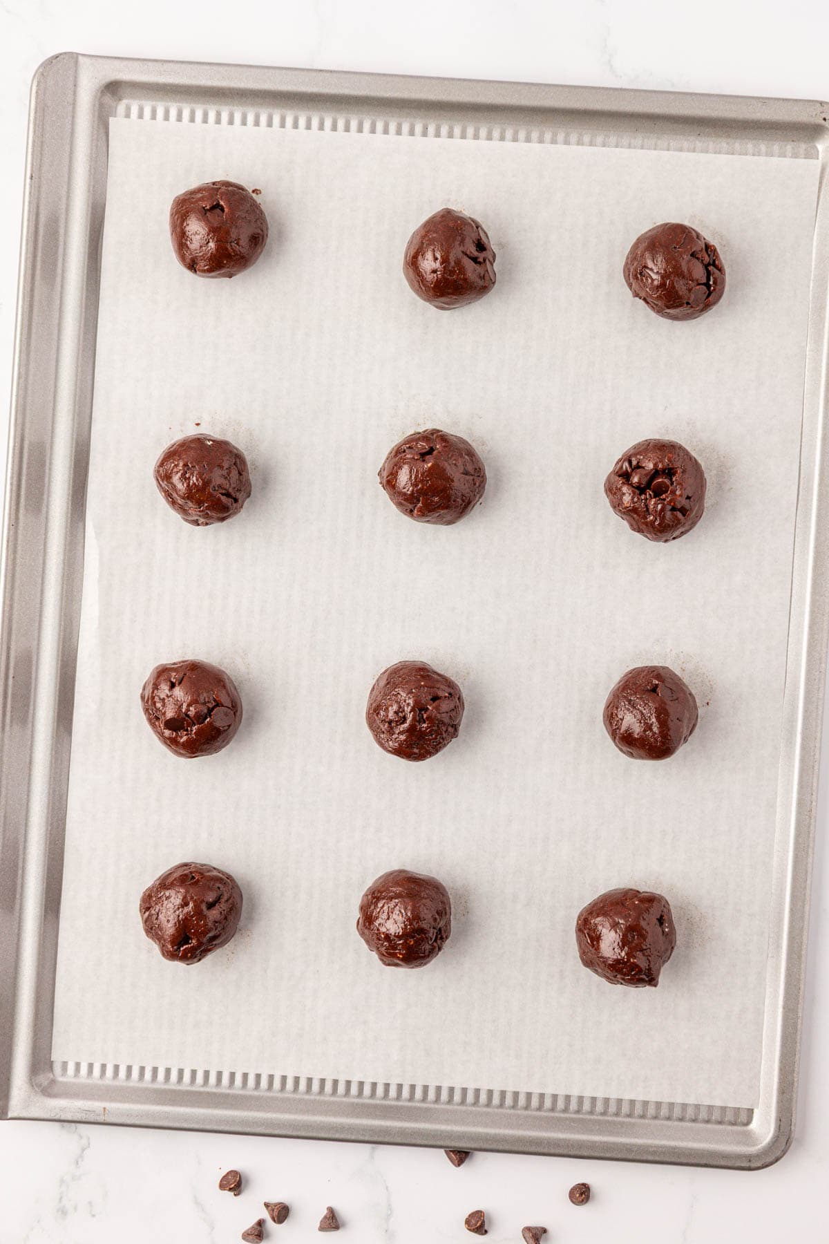 batter rolled into balls on a baking sheet