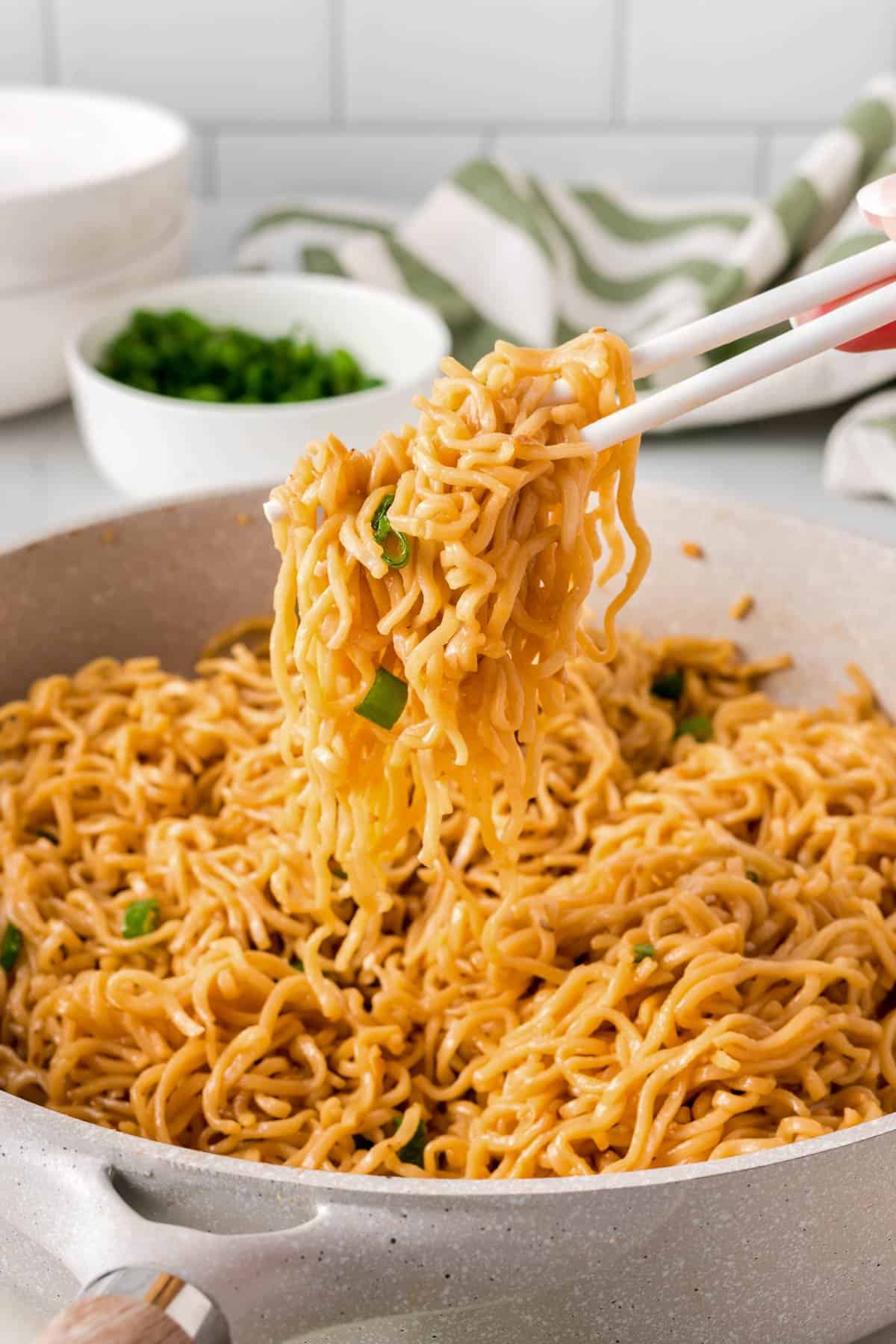 chopsticks taking ramen noodles from the skillet