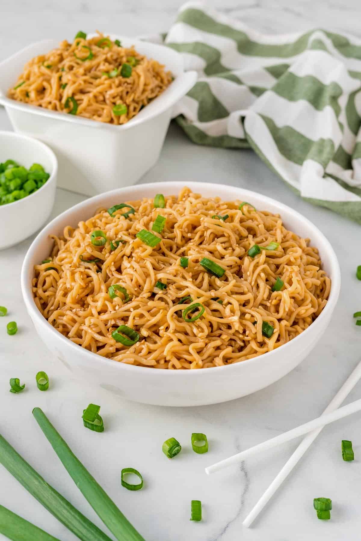 sesame garlic ramen noodles in a white bowl topped with green onions