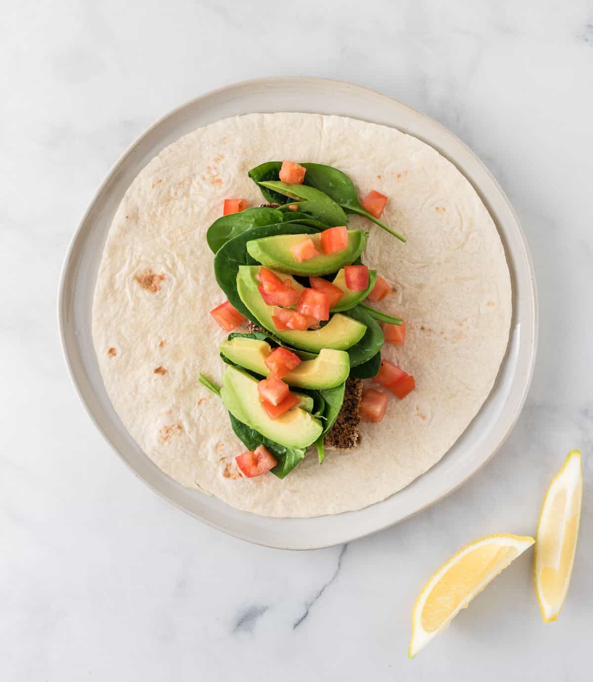 tofu wrap with tofu, spinach, avocado, tomato, and lemon