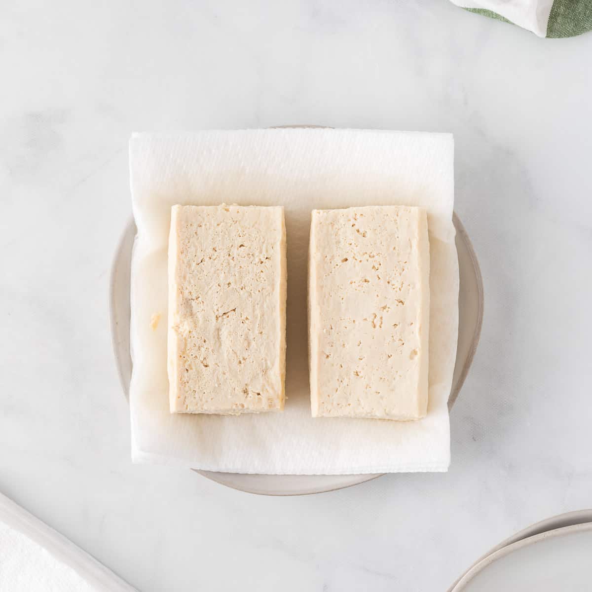 tofu blocks on a paper towel lined plate