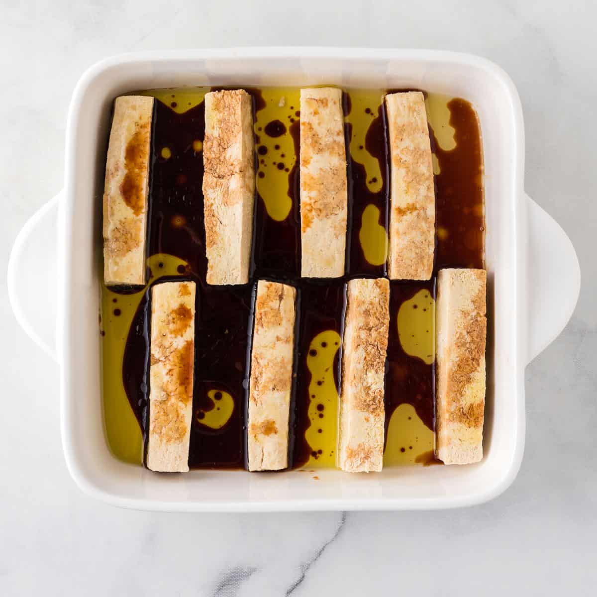 tofu marinating in soy sauce and olive oil