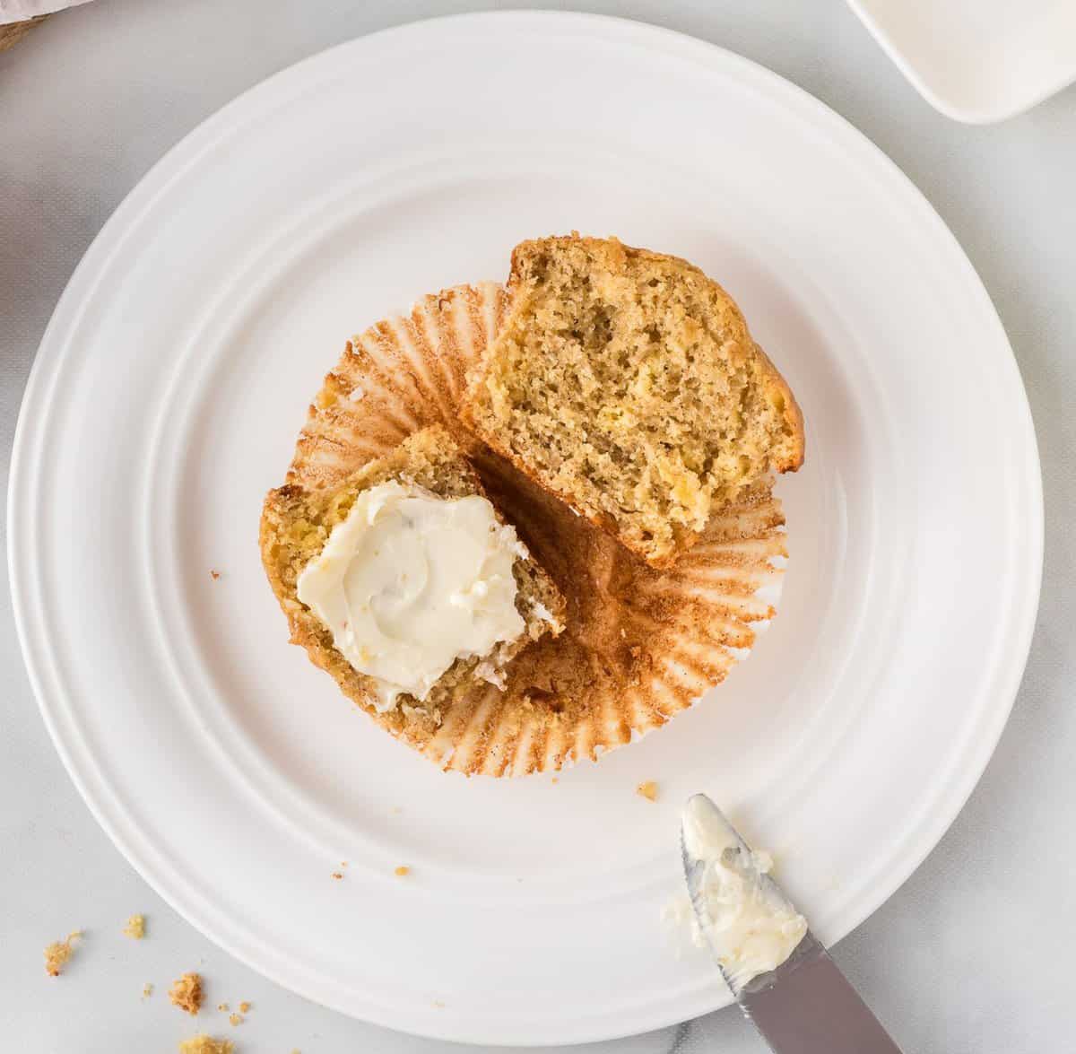 banana muffin cut in half with butter on one side
