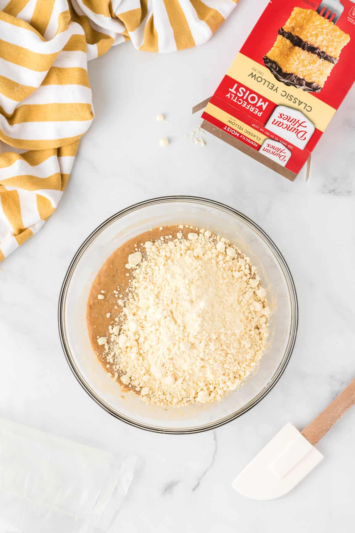 adding a box of yellow cake mix to the muffin batter