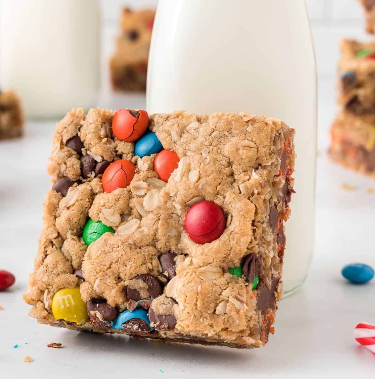 monster cookie bar propped up on a glass of milk