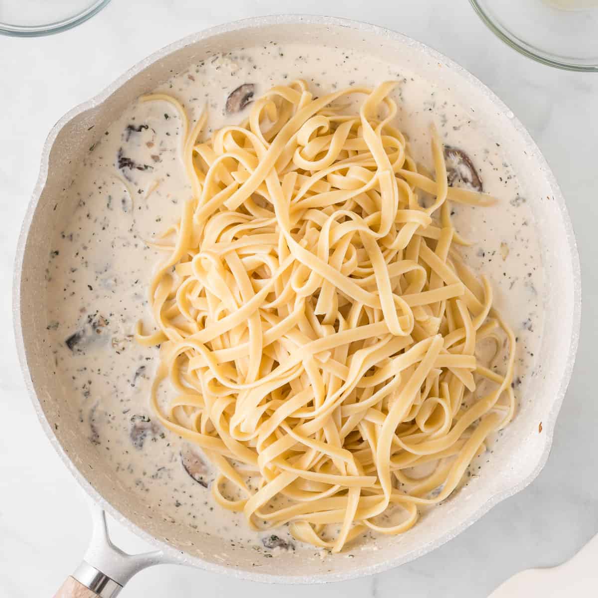 adding the pasta to the mushroom cream sauce