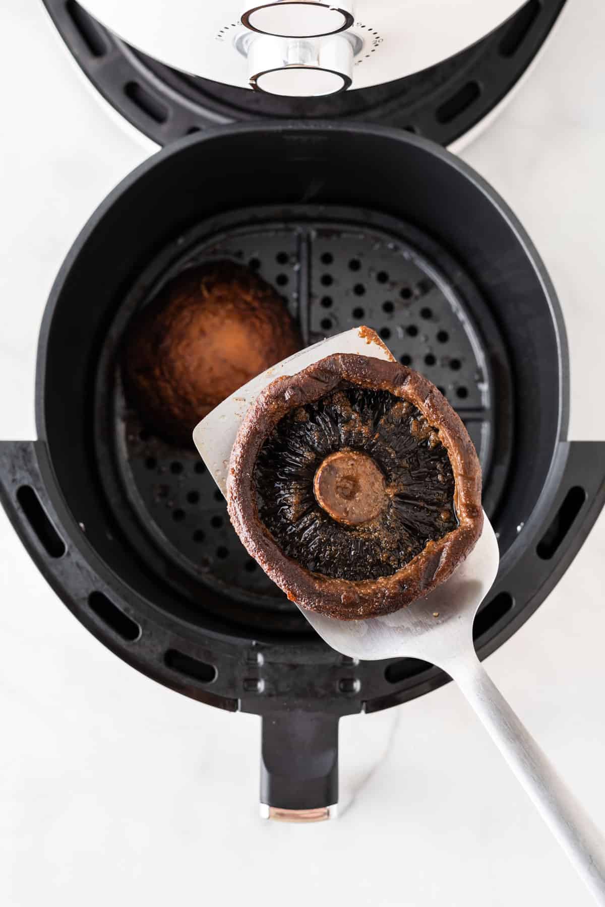 taking a mushroom from the air fryer